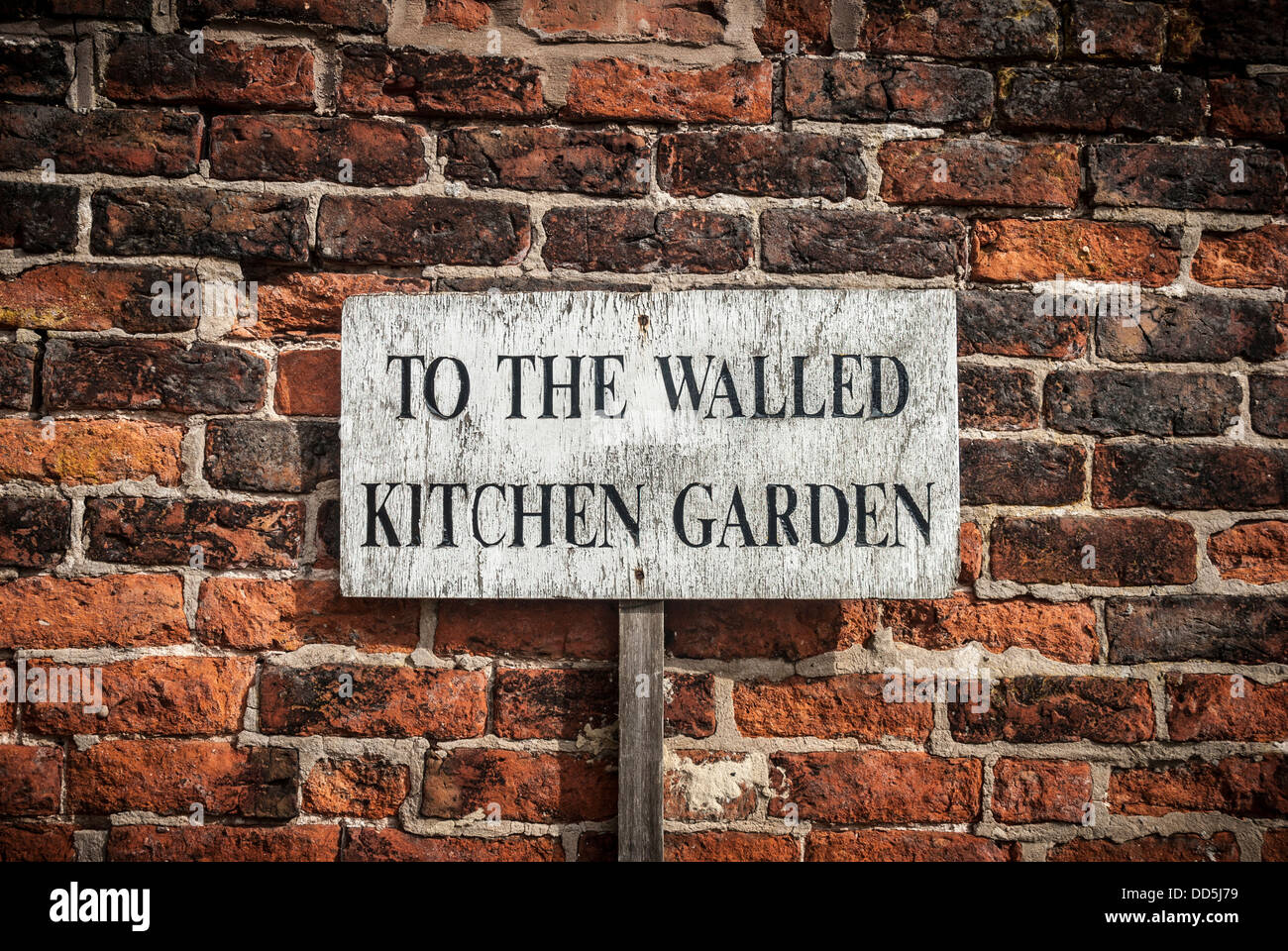 Vieux, cuisine rustique jardin signer contre un mur. Banque D'Images