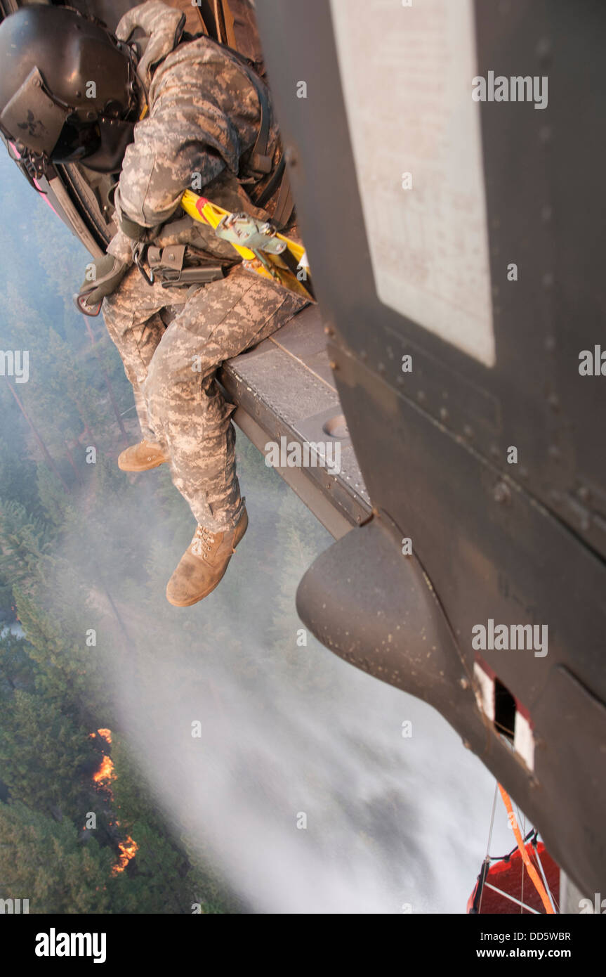 Le Sgt. Chris Boni, chef d'équipage de la Garde nationale de Californie, 1-140ème bataillon de l'Aviation (Air Assault) sur la base de formation conjointe de Los Alamitos (JFTB), les rejets de l'eau sur la tête arrosant le rim fire ci-dessous près de Yosemite National Park. Le Sapin Rim Banque D'Images