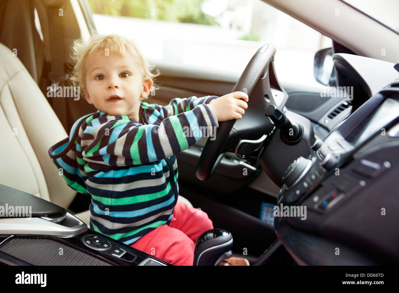 Allemagne, Bonn, Baby Boy sitting in car et maintenant le volant Banque D'Images