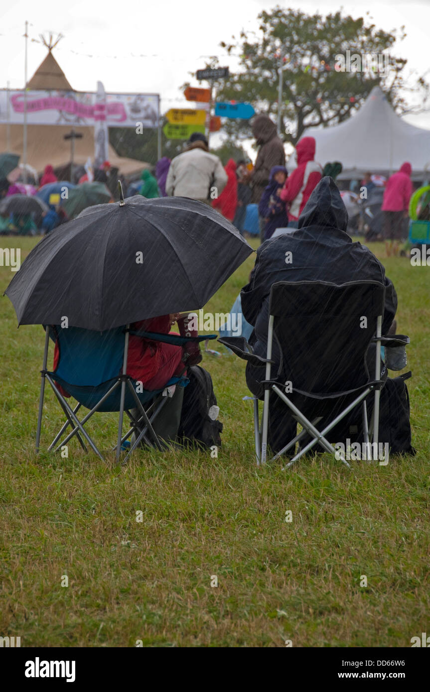 Vue verticale de personnes à un festival de musique assis sous la pluie battante. Banque D'Images