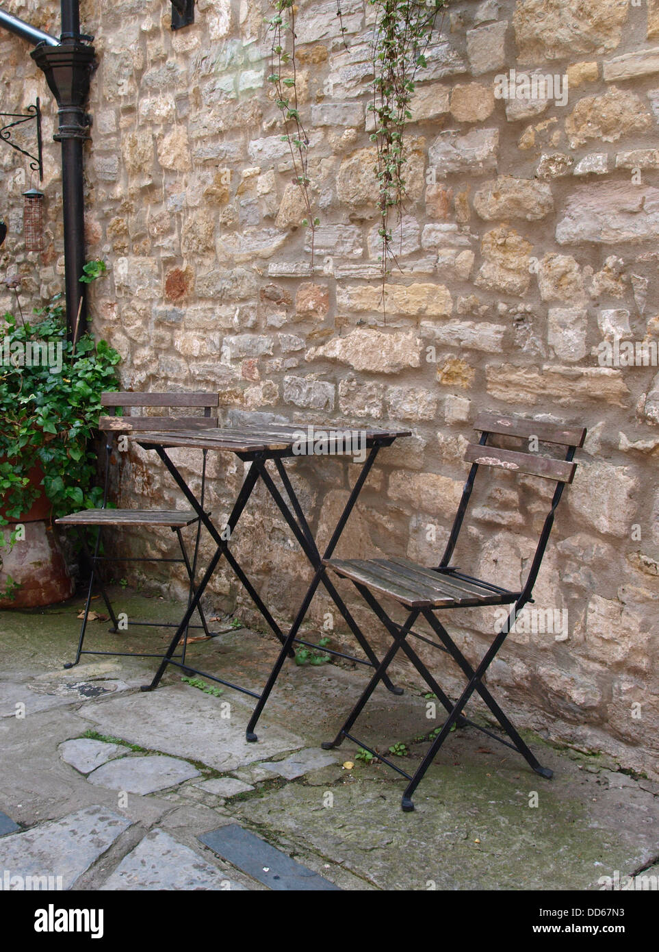 Table et chaises de jardin contre un mur de pierre, UK 2013 Banque D'Images