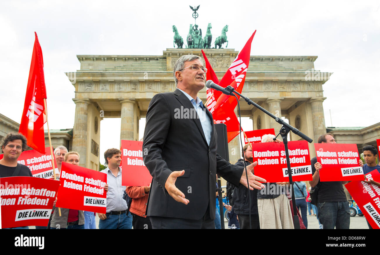 Berlin, Allemagne. 27 août, 2013. Le chef du parti de Die Linke (La Gauche), Bernd Riexinger, prend la parole lors d'une manifestation en face de la porte de Brandebourg à Berlin, Allemagne, le 27 août 2013. Le Parti de Gauche est contre une intervention militaire en Syrie. Des affiches à l'arrière-plan lire 'bombes n'apportez pas de paix !". Photo : HANNIBAL/dpa/Alamy Live News Banque D'Images