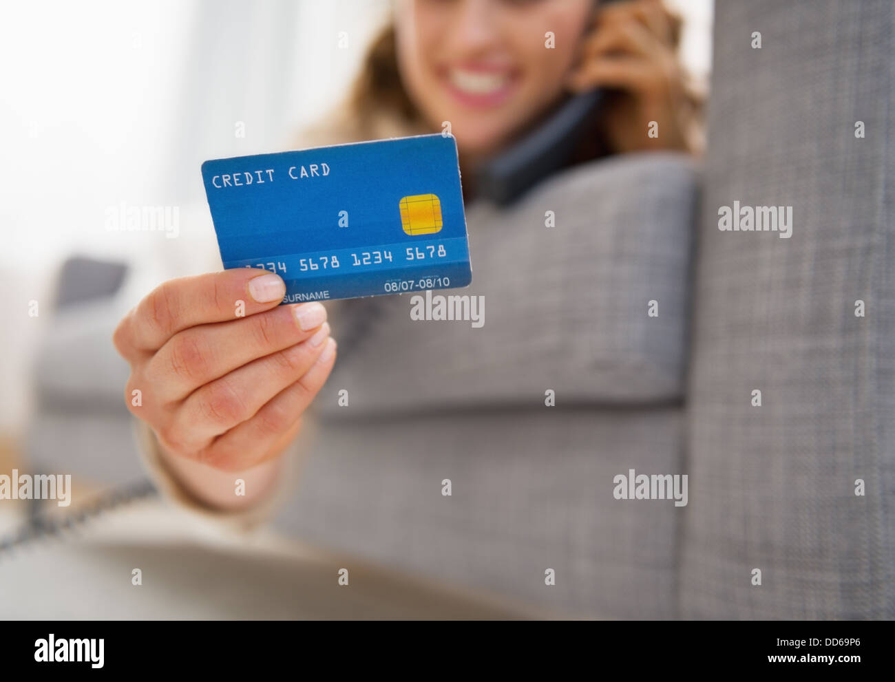 Gros plan sur carte de crédit en main de jeune femme parlant téléphone Banque D'Images