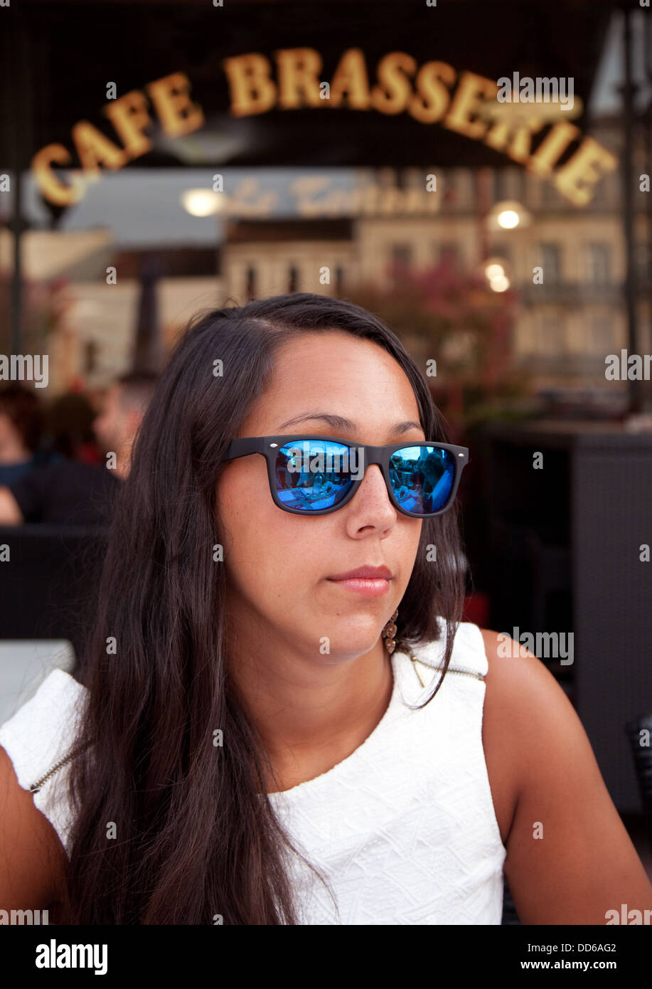 Belle fille avec lunettes de soleil assise dans un café français à Villeneuve-sur-Lot, France, Europe Banque D'Images