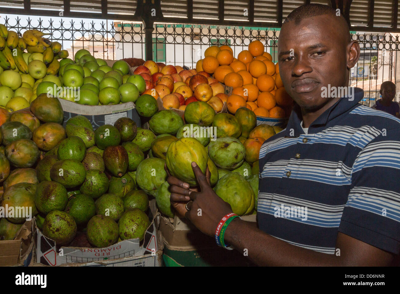 Dakar, Sénégal. Vendeur marché Kermel montrant un 'Mango' Pomme. Banque D'Images