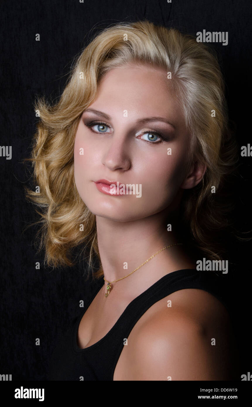 Un modèle de beauté pose farouchement en studio, l'éclairage dramatique avec cheveux inspiré de Marilyn Monroe Banque D'Images