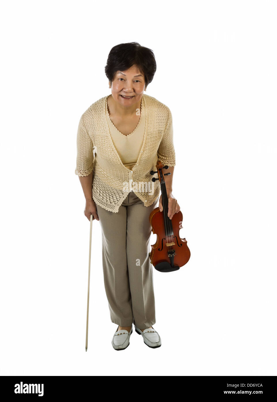 Photo verticale d'un senior woman bowing après avoir joué du violon sur fond blanc Banque D'Images
