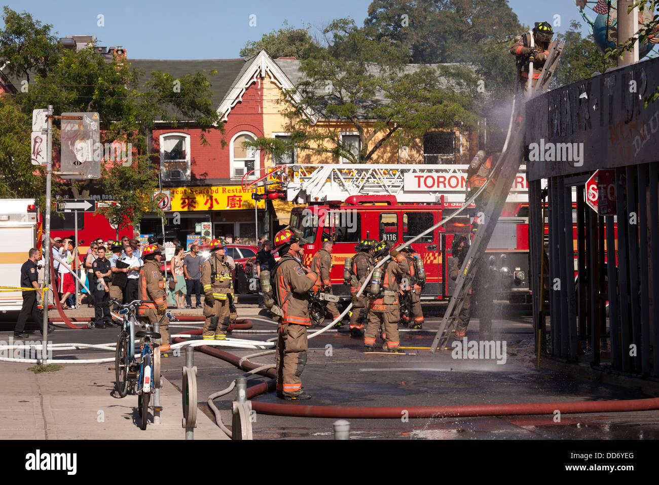 Un pompier douses le bois de surround un bâtiment abandonné qui était en feu dans la région de Kensington Market, Toronto, Ontario, Canada Banque D'Images