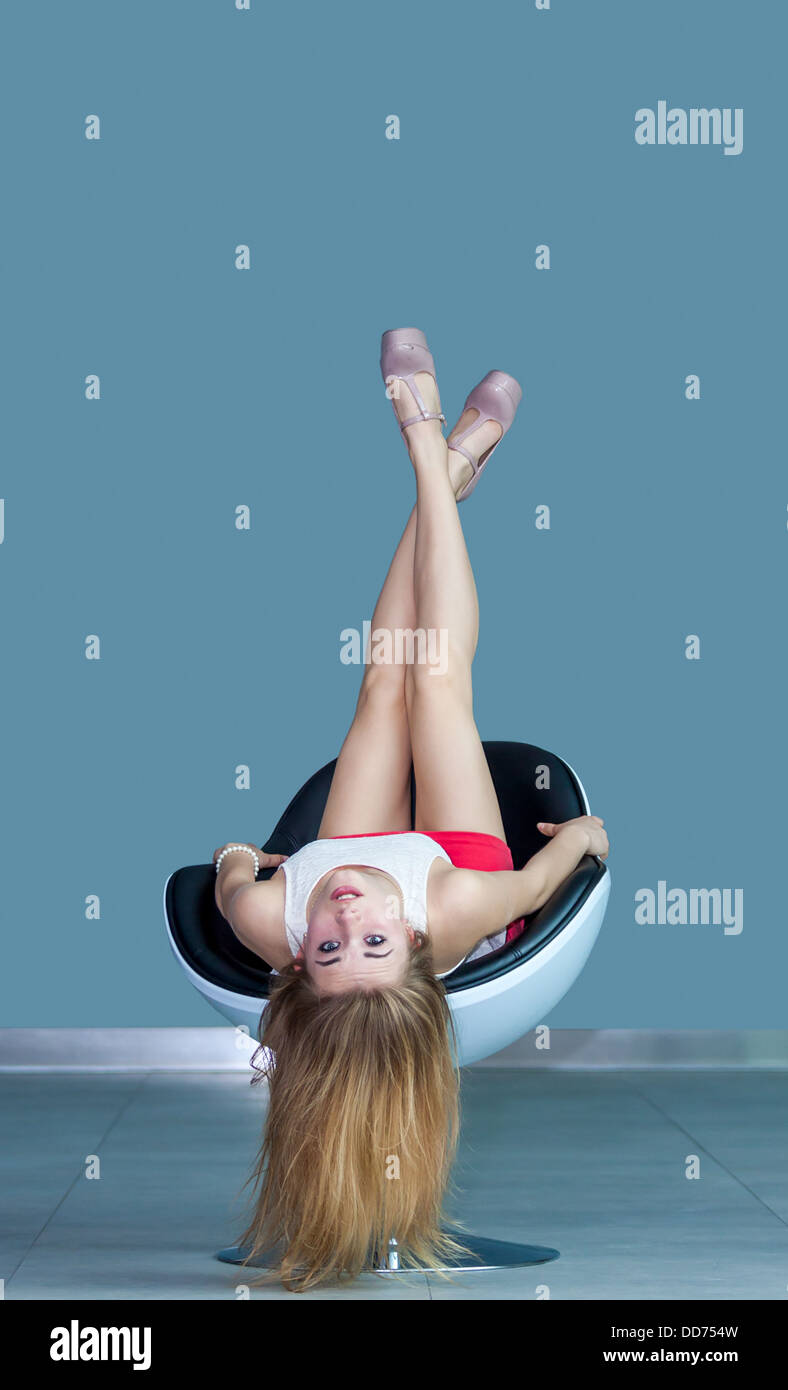 Young Attractive Blonde Girl Lying On Président à l'envers Banque D'Images