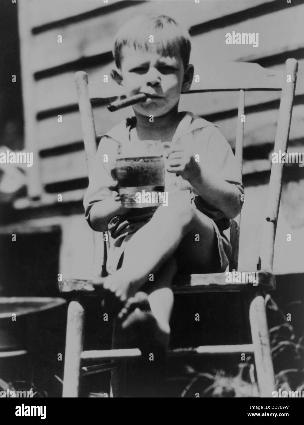 « Le plus grave du monde' 3 ans, est assis dans la chaire de bière en fumant un cigare, 1935. (BSLOC 2013 8 101) Banque D'Images