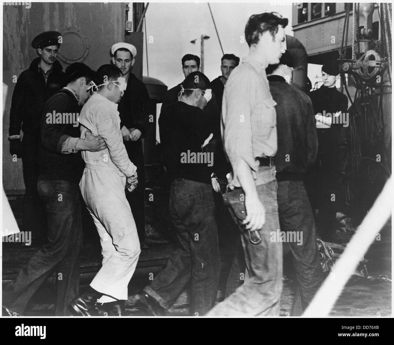 Les prisonniers de guerre japonais arrivent à Dutch Harbor, en Alaska, pendant la première Guerre mondiale. Les prisonniers, les yeux bandés et sous une garde lourde, ont été amenés aux États-Unis dans le cadre d'un effort plus large impliquant des soldats japonais capturés. La scène reflète la nature dure et secrète des processus de détention en temps de guerre. Banque D'Images