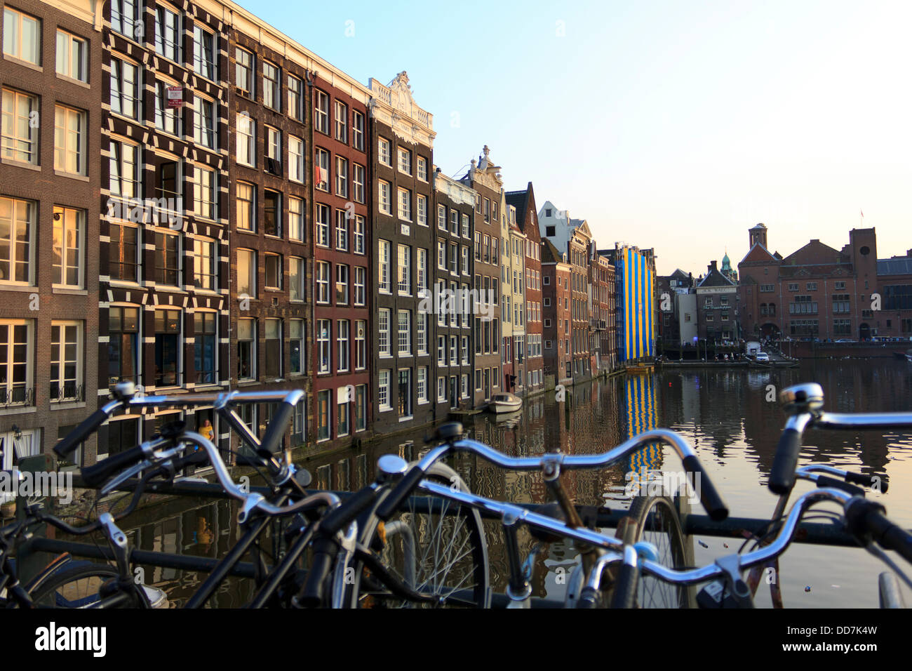 Bâtiments hollandais iconique au crépuscule avec des vélos garés le long du côté du canal à Amsterdam. Banque D'Images