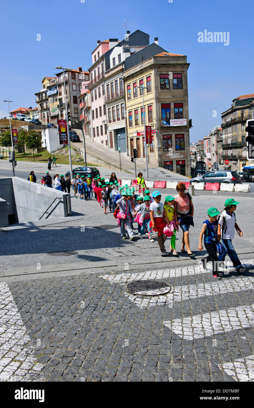 Les enfants de l'école portugaise sur une sortie avec leurs enseignants, avec capuchons de couleur,en dehors de la gare,Porto,Porto,Portugal Banque D'Images