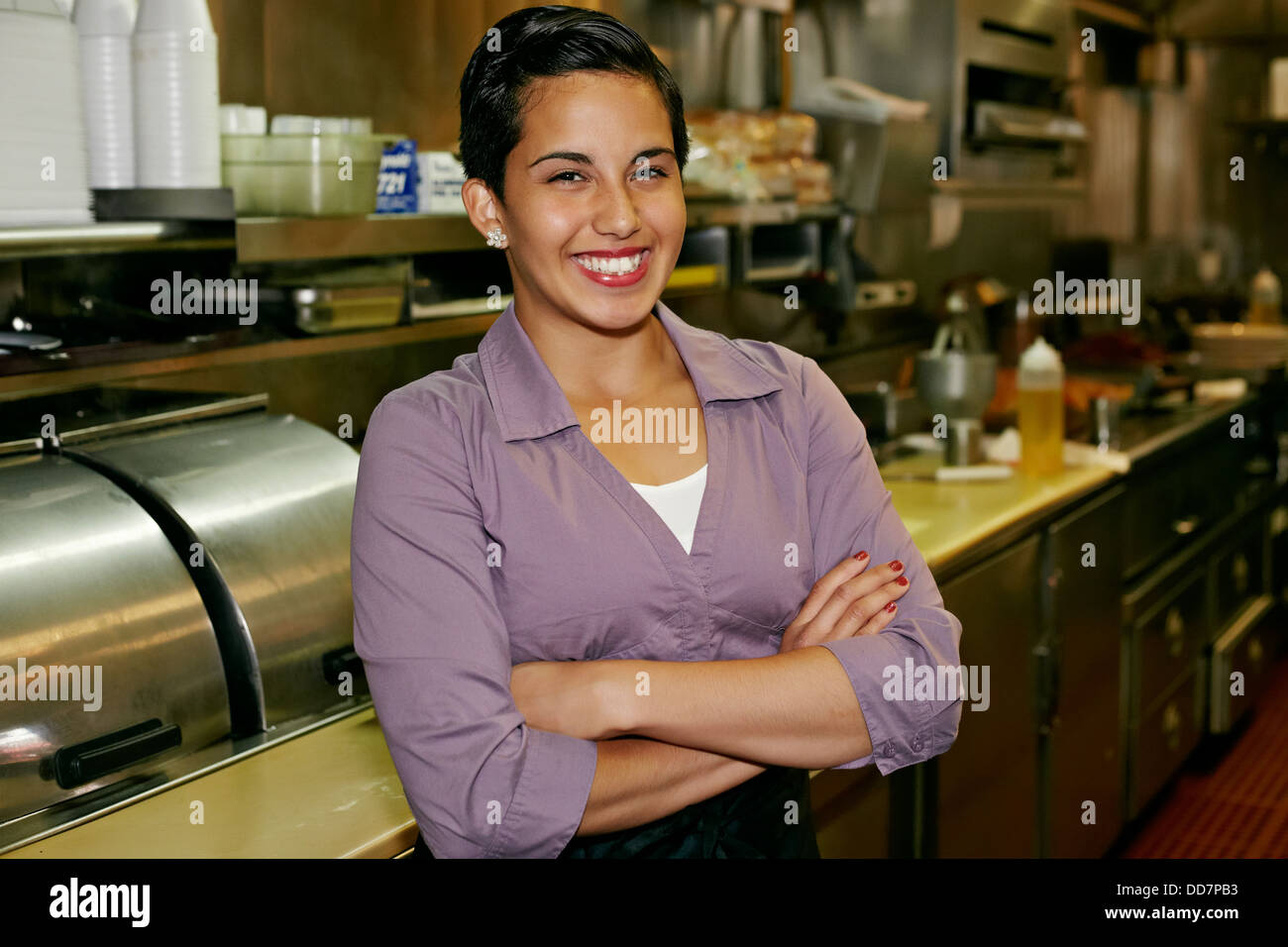 Hispanic waitress smiling in restaurant Banque D'Images