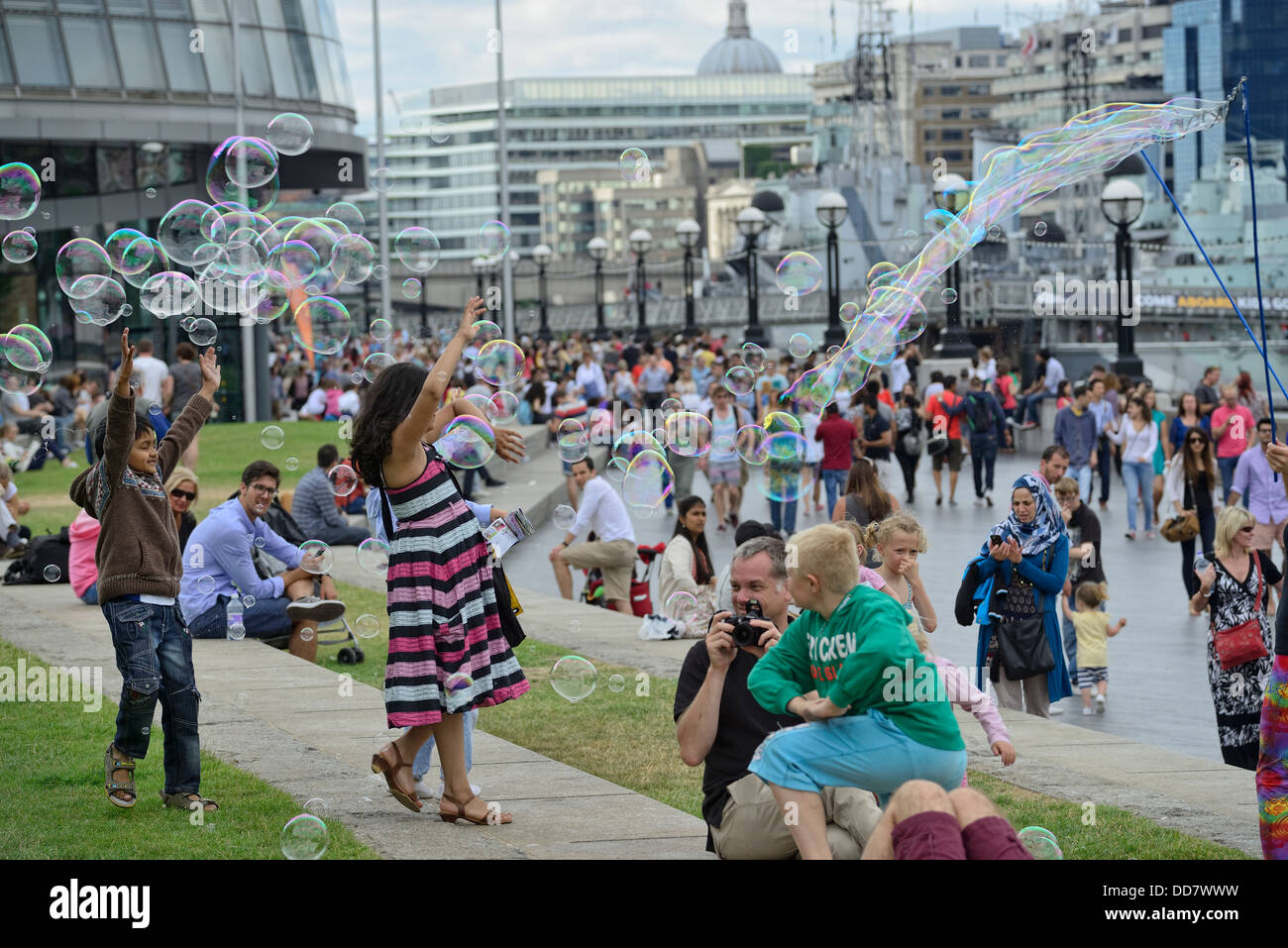 Les enfants s'amusant avec les bulles de savon à Londres à la tamise les banques, juste à côté du pont de Londres Banque D'Images