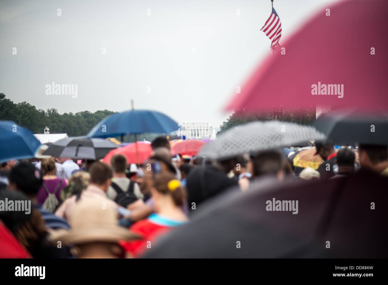 WASHINGTON DC, USA - Les gens se protéger de la pluie légère avec des parasols sur le National Mall à Washington DC lors de la commémoration du 50e anniversaire de la célèbre Marche sur Washington de 1963 mémoires pour droit civil, Martin Luther King Jr's 'J'ai fait un rêve" discours. Banque D'Images