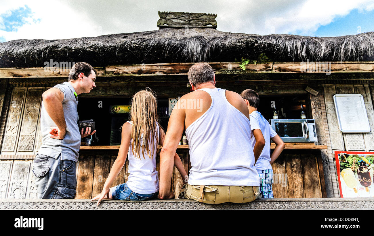 Une famille en attente d'un verre au coin d'une petite maison en bois et exotiques. 4 personnes blanche européenne Banque D'Images