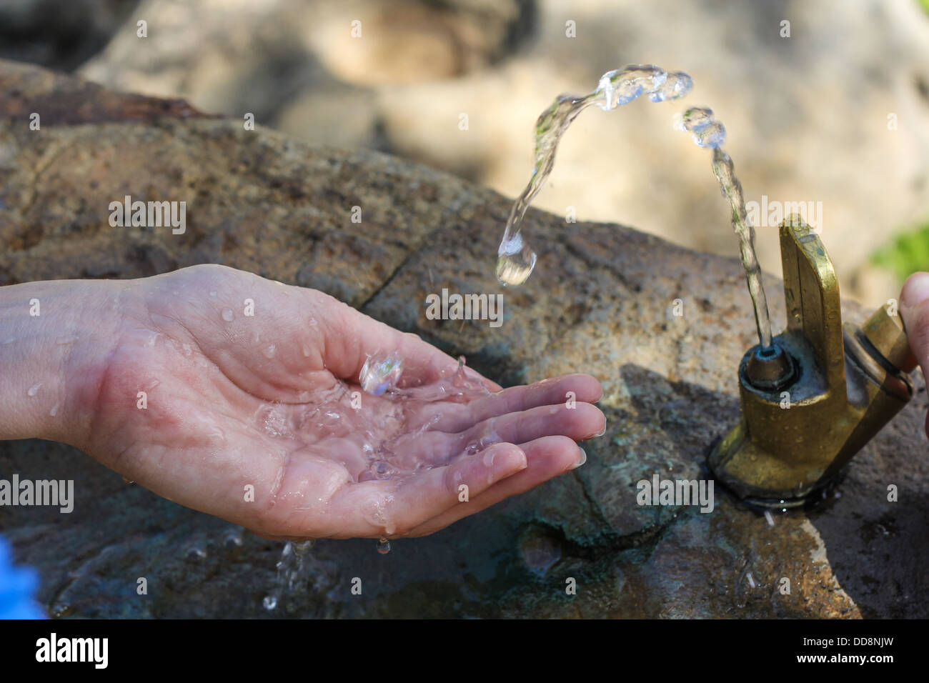 L'eau qui sort de l'onglet et les projections dans la main Banque D'Images