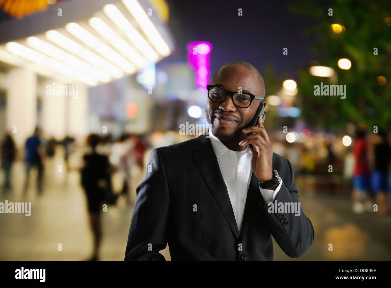 Black businessman talking on cell phone on city street Banque D'Images