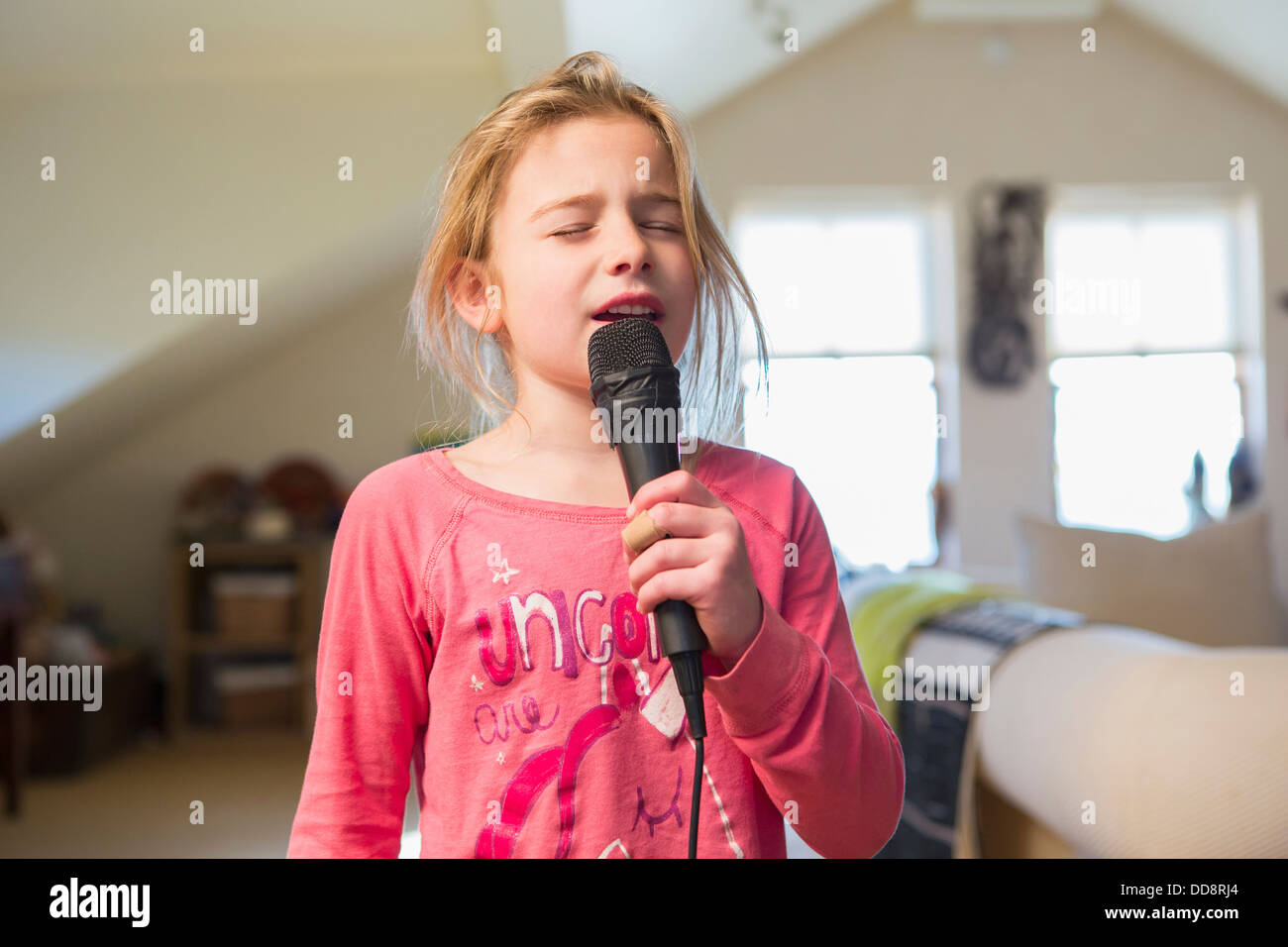 Caucasian girl singing karaoke at home Banque D'Images