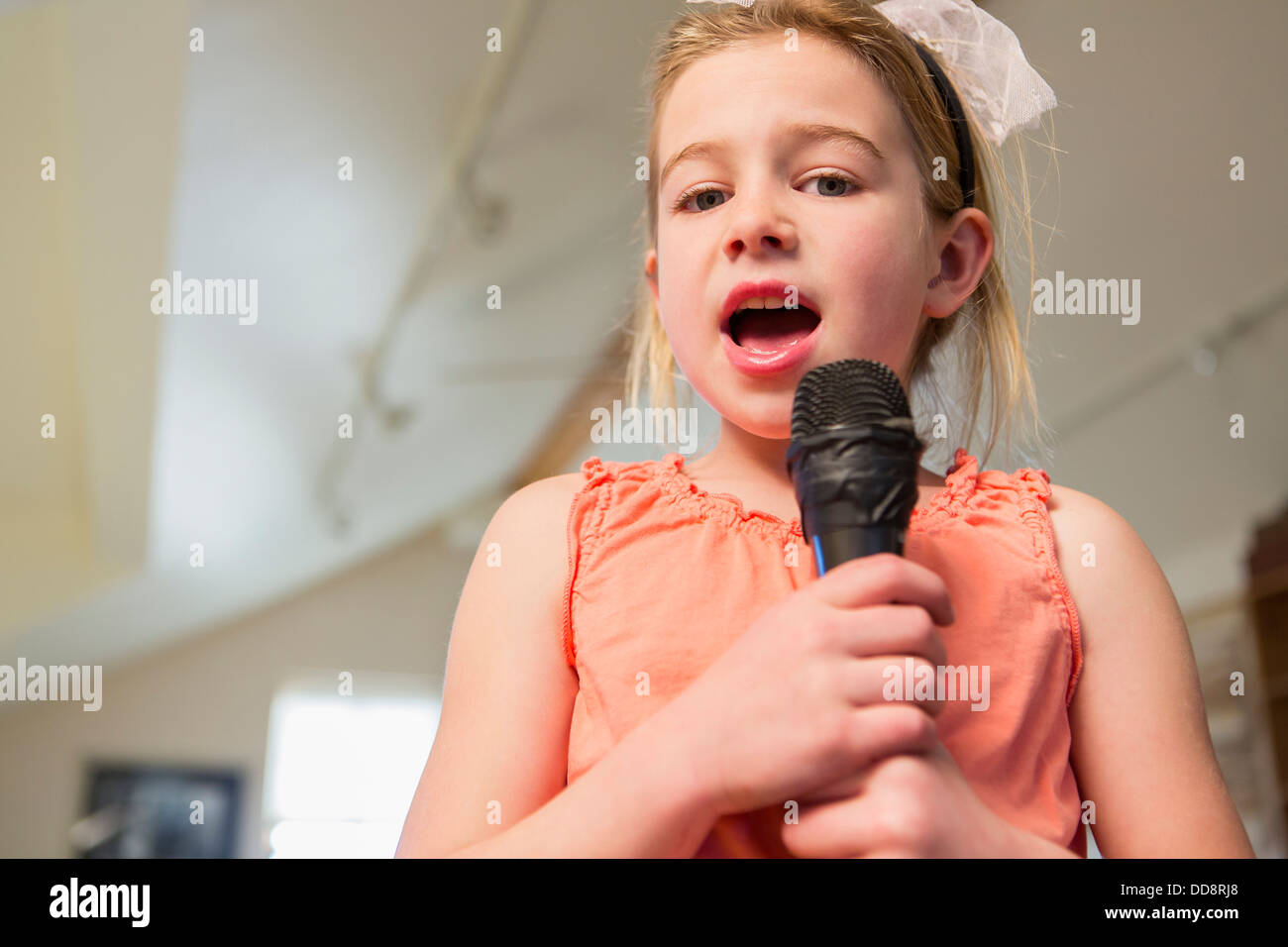 Caucasian girl singing karaoke at home Banque D'Images