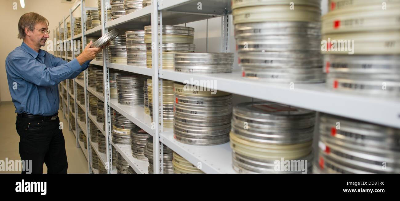 Le directeur du département pour la restauration et la conservation du film , Egbert Koppe, se trouve devant des étagères remplies de bobines de film et des films stockés dans des boîtes d'argent dans un local de stockage à la German Federal Film Archive à Berlin, Allemagne, 12 août 2013. Koppe s'inquiète de l'état de désolation de certains des dépôts de films qui sont répartis dans des installations différentes à différents endroits. Les négociations sont en cours depuis des années au sujet d'un nouveau film de l'installation centrale pour la conservation et l'archivage dans Berlin, près de Berlin. Photo : Patrick Pleul Banque D'Images