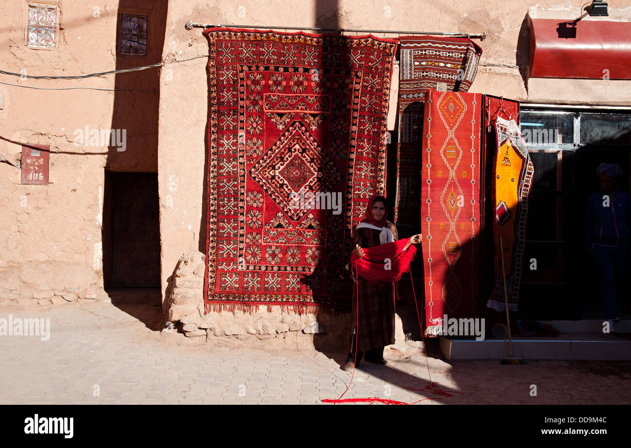 Femme en face d'une boutique de tapis dans le mellah (quartier juif), Ouarzazate, Maroc Banque D'Images