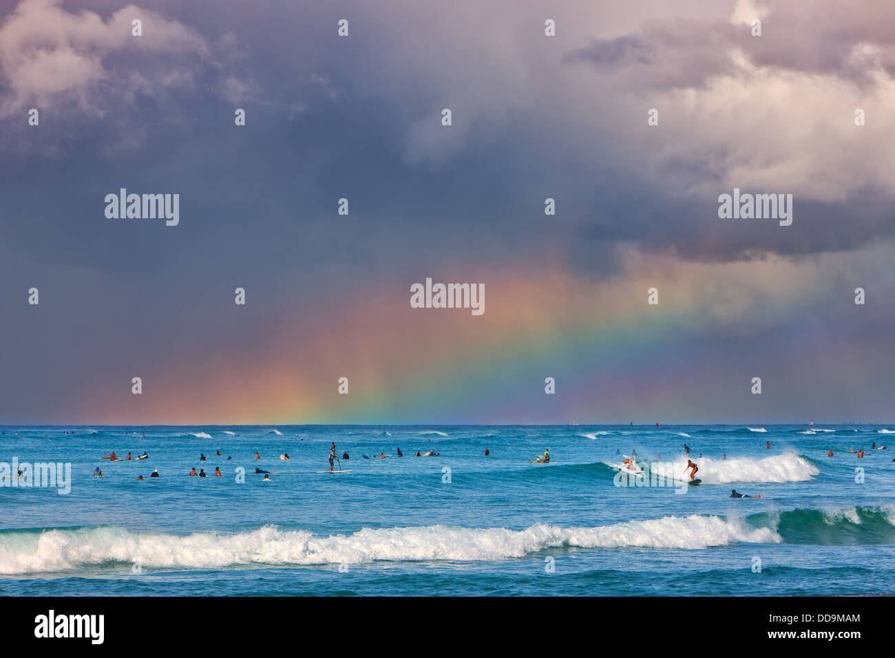 Surfers under the rainbow à la célèbre plage de Waikiki, Honolulu, Oahu, Hawaii Banque D'Images
