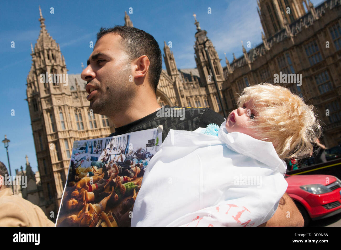 Londres, Royaume-Uni. Août 29, 2013. Un homme porte une poupée "mortes" pendant une manifestation devant le parlement britannique par les Syriens pour exiger des mesures contre le régime Assad pour des attaques aux armes chimiques contre des civils. Crédit : Paul Davey/Alamy Live News Banque D'Images