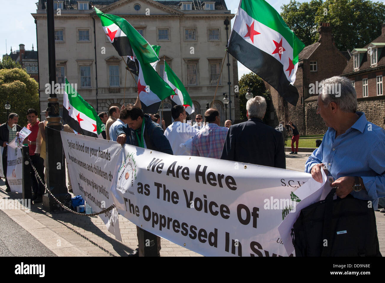 Londres, Royaume-Uni. Août 29, 2013. Maintenez les militants des banderoles lors d'une manifestation devant le parlement britannique par des Syriens pour exiger des mesures contre le régime Assad pour des attaques aux armes chimiques contre des civils. Crédit : Paul Davey/Alamy Live News Banque D'Images
