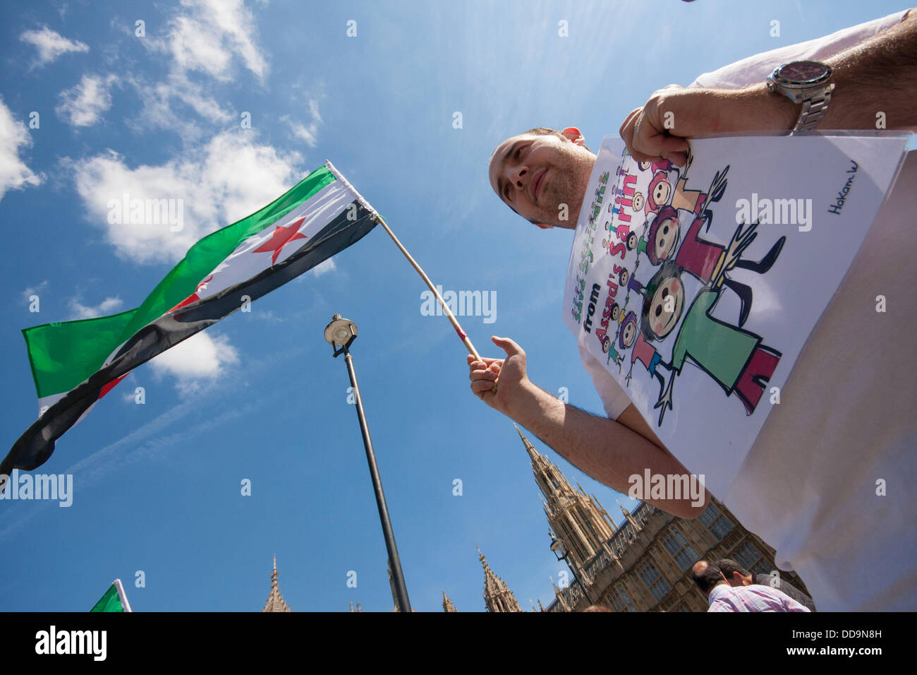 Londres, Royaume-Uni. Août 29, 2013. Une activiste tenir son drapeau syrien et de l'affiche pendant une manifestation devant le parlement britannique par les Syriens pour exiger des mesures contre le régime Assad pour des attaques aux armes chimiques contre des civils. Crédit : Paul Davey/Alamy Live News Banque D'Images