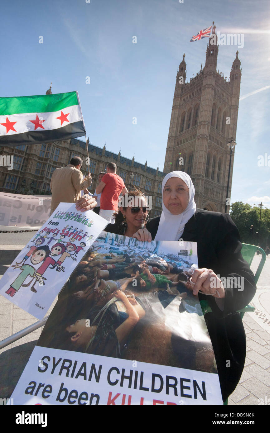 Londres, Royaume-Uni. Août 29, 2013. Une femme met en garde contre des enfants sont tués en Syrie lors d'une manifestation devant le parlement britannique par les Syriens pour exiger des mesures contre le régime Assad pour des attaques aux armes chimiques contre des civils. Crédit : Paul Davey/Alamy Live News Banque D'Images