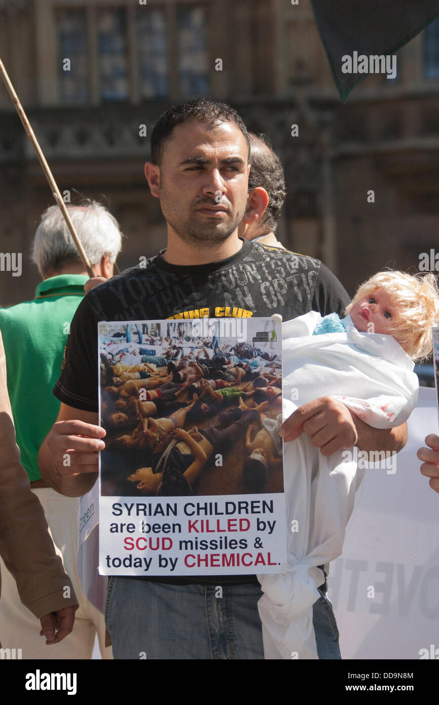 Londres, Royaume-Uni. Août 29, 2013. Un homme met en lumière les décès d'enfants au cours d'une manifestation devant le parlement britannique par les Syriens pour exiger des mesures contre le régime Assad pour des attaques aux armes chimiques contre des civils. Crédit : Paul Davey/Alamy Live News Banque D'Images