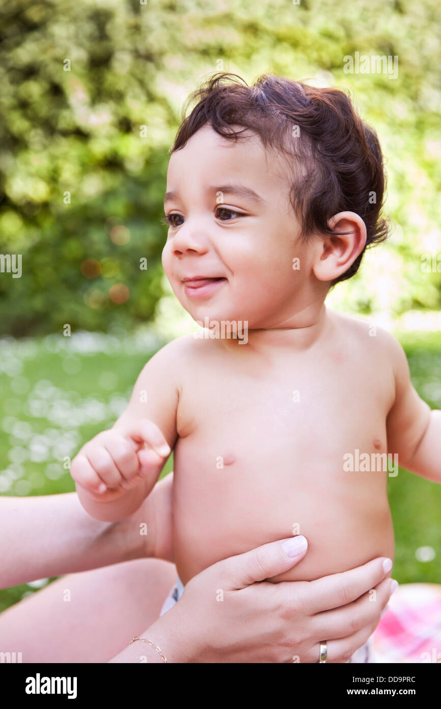 Mère avec bébé garçon assis sur une couverture, smiling Banque D'Images