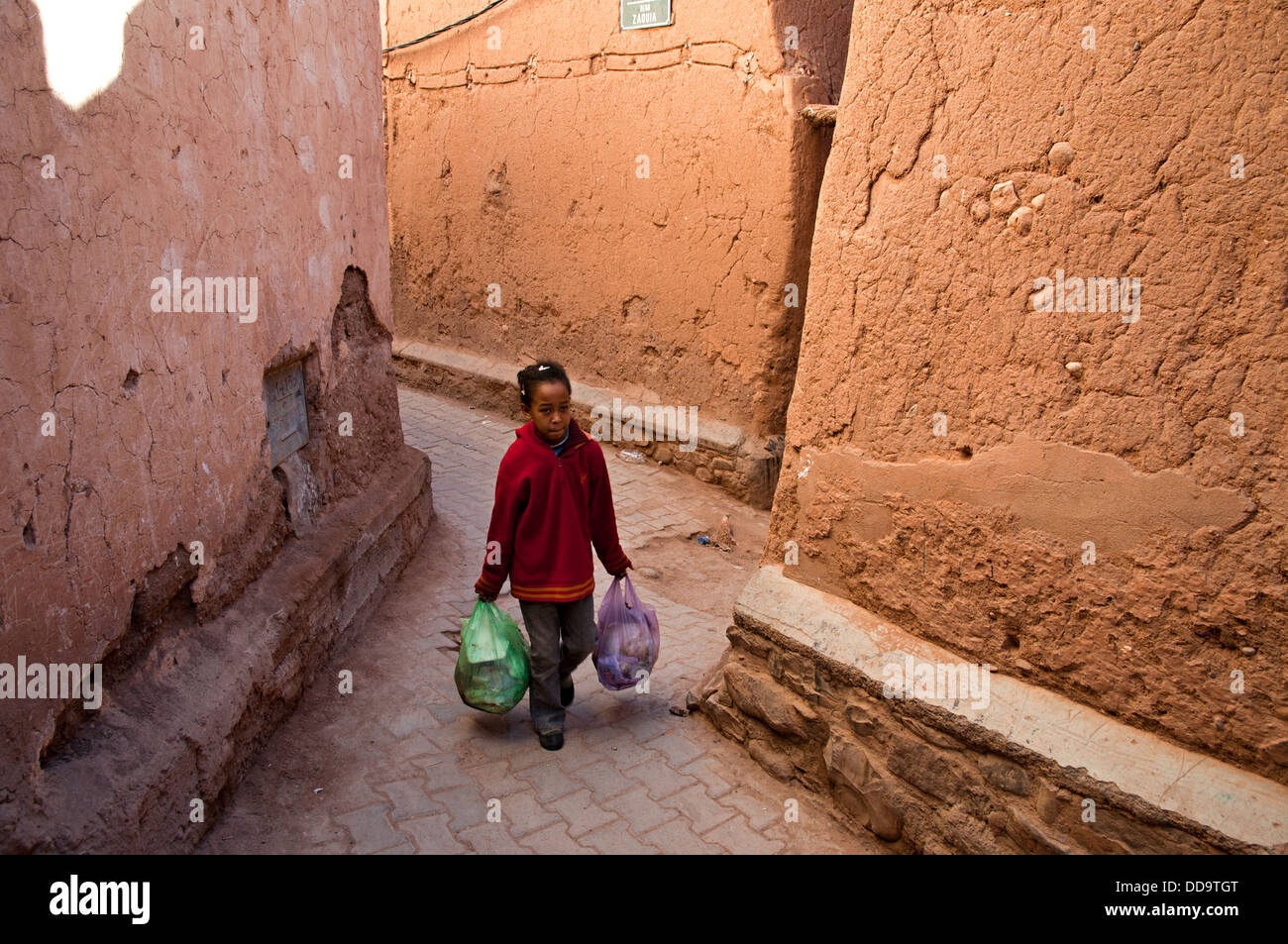 Fille qui marche dans les rues de la mellah (quartier juif), Ouarzazate, Maroc Banque D'Images