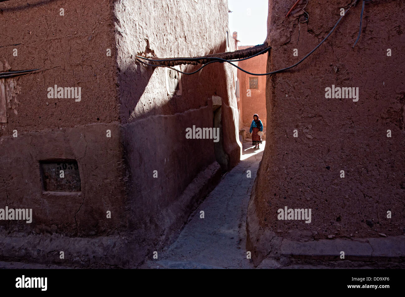 Femme marche par une ruelle dans le mellah (quartier juif). Ouarzazate, Maroc Banque D'Images