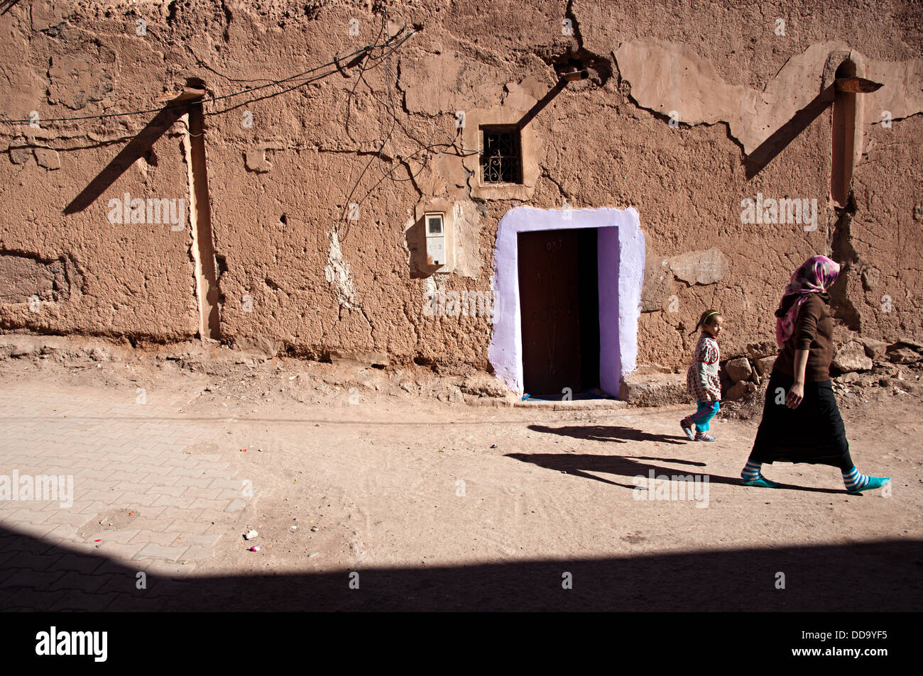 Femme et enfant marcher par les rues dans le mellah (quartier juif). Ouarzazate, Maroc Banque D'Images