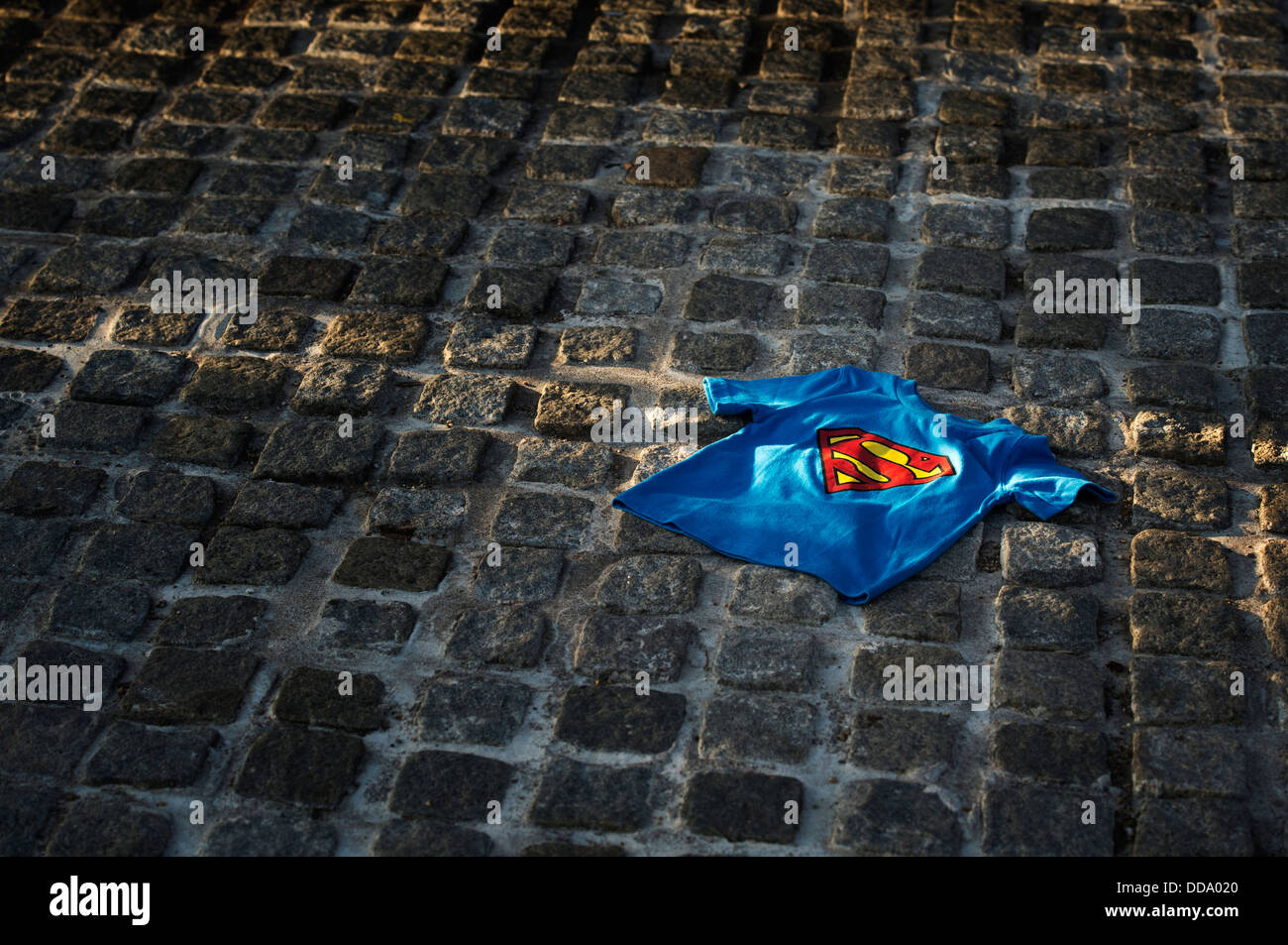 T shirt superman enfant éclairée par le soleil sur une rue pavée. UK Banque D'Images