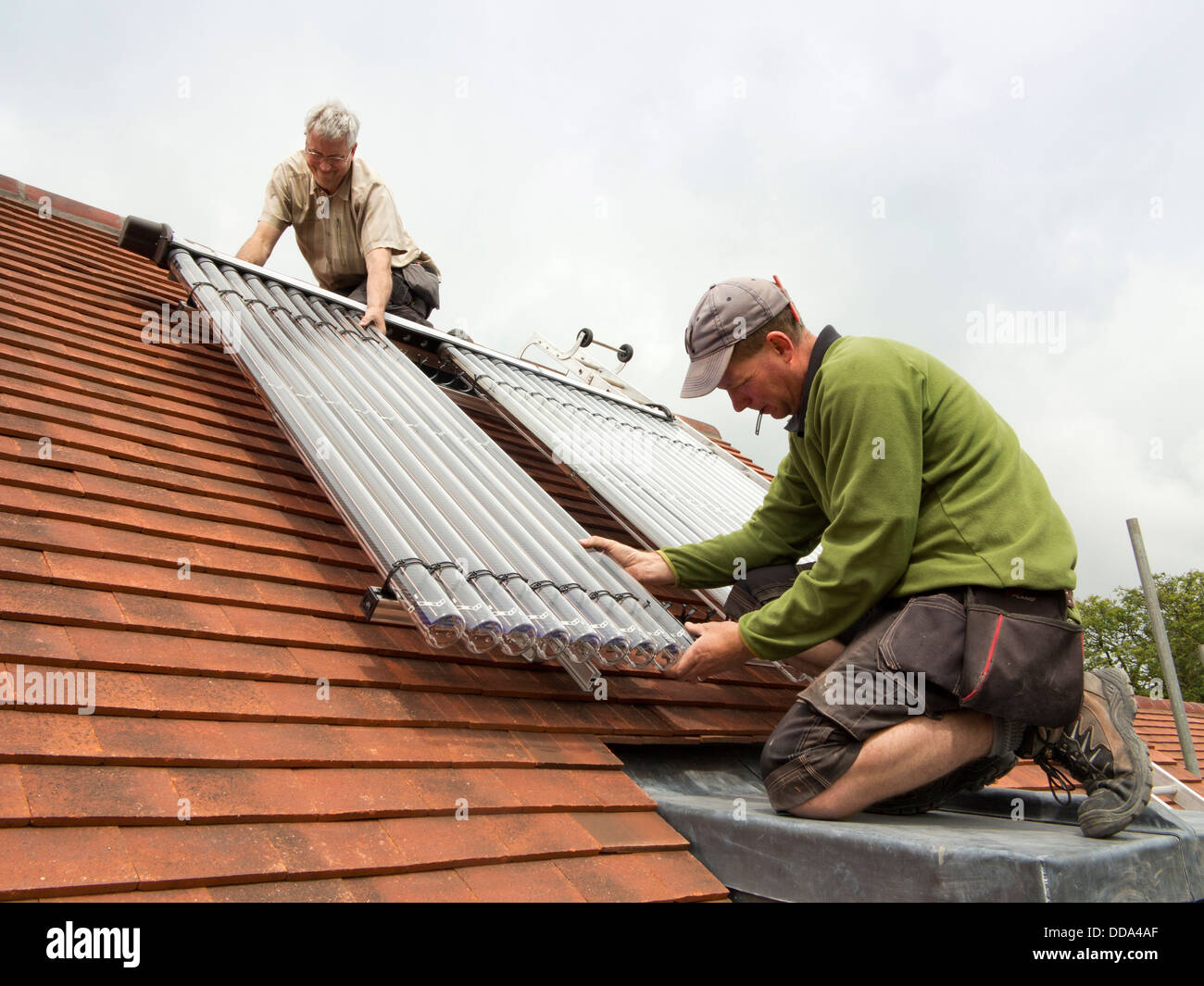 L bâtiment maison, l'installation d'eau chaude solaire thermique Veissmann chauffage tubes sur toit de nouvelle construction Banque D'Images