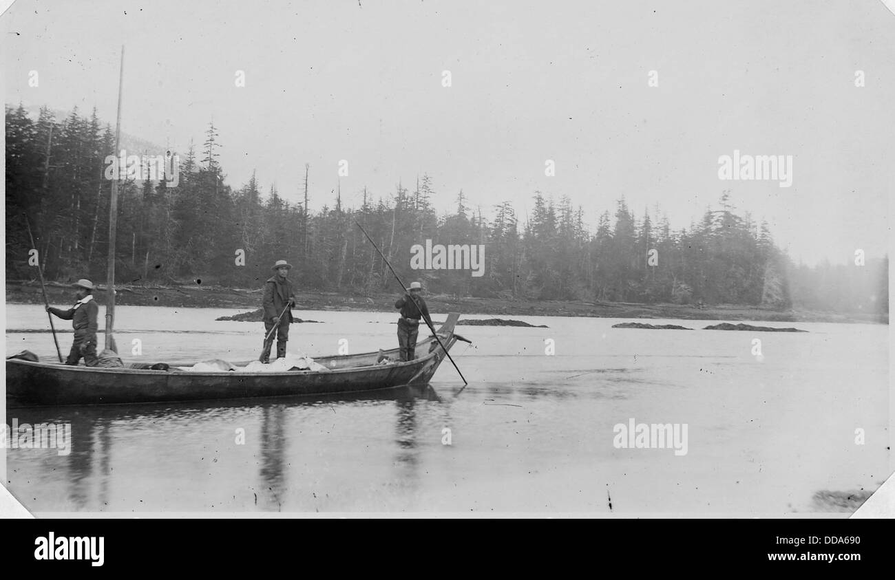 Cette image représente trois individus autochtones dans un canot, possiblement sur une rivière ou un lac, reflétant les méthodes traditionnelles de transport et le lien avec la nature qui prévaut dans de nombreuses cultures autochtones. Banque D'Images