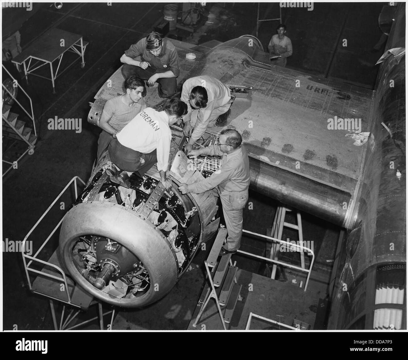 Sous l'étroite supervision d'un contremaître, un nouveau moteur est bien installé dans un bombardier B-25 à l'Amérique du Nord... - - 196385 Banque D'Images