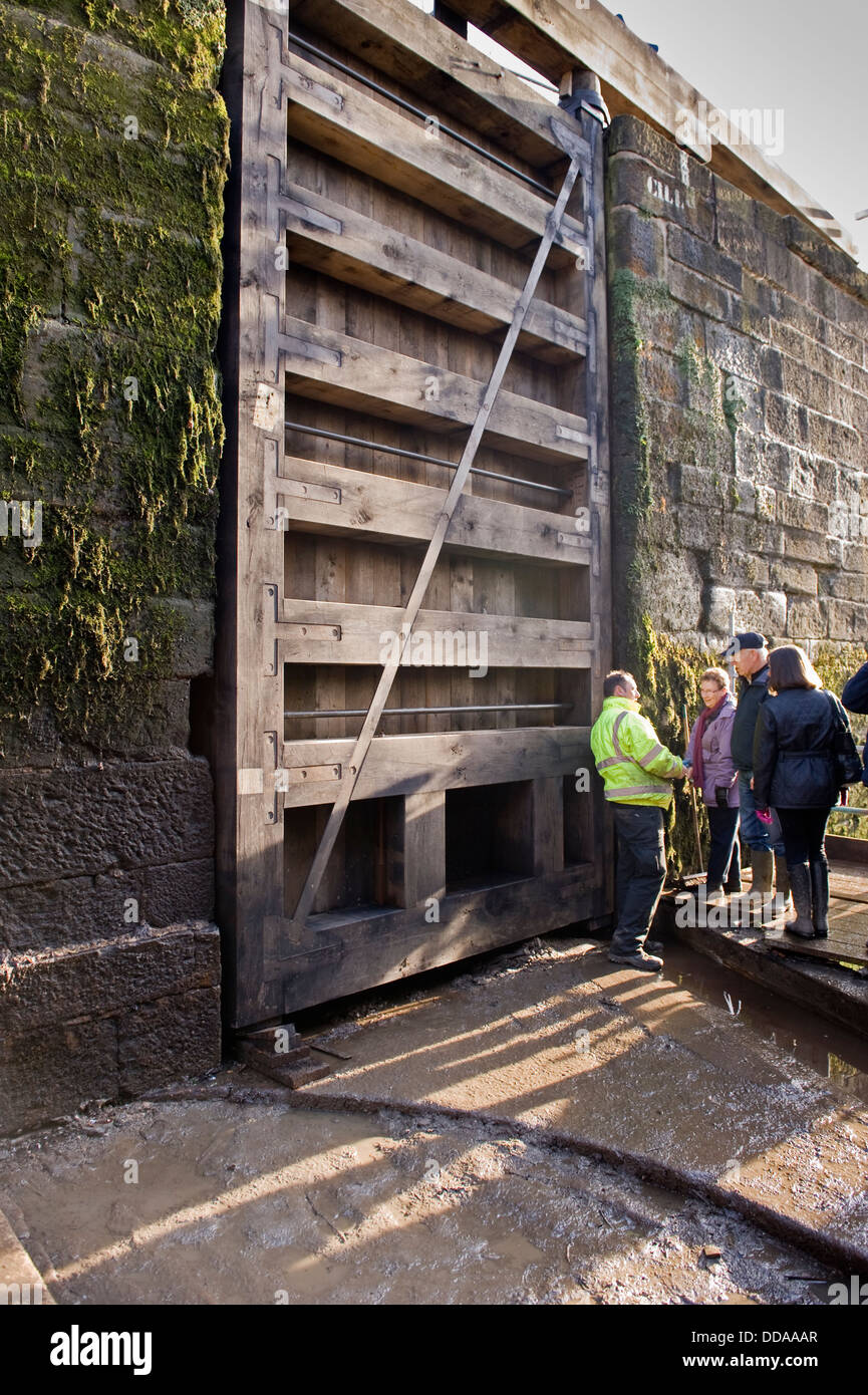 Les gens à l'intérieur d'une écluse drainés à des travaux de rénovation à l'énorme porte en bois - journée portes ouvertes, Bingley's hausse cinq écluses, West Yorkshire, Angleterre, Royaume-Uni. Banque D'Images