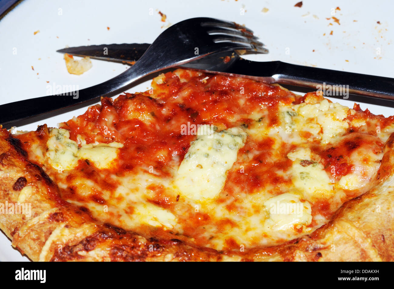 Partie mangé de fromage et de tomate pizza avec un couteau et fourchette. Banque D'Images