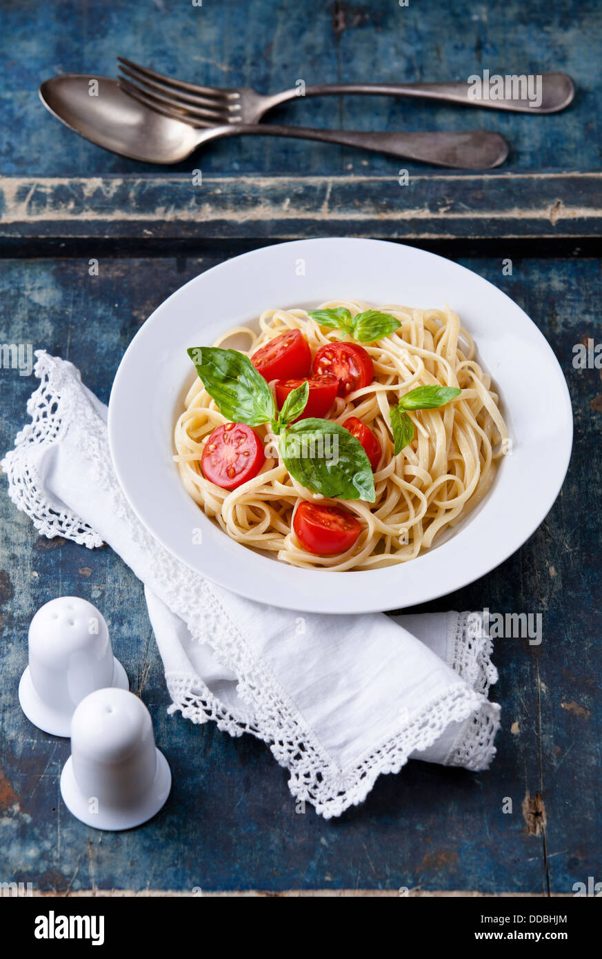 Spaghetti à la tomate et basilic on blue background Banque D'Images