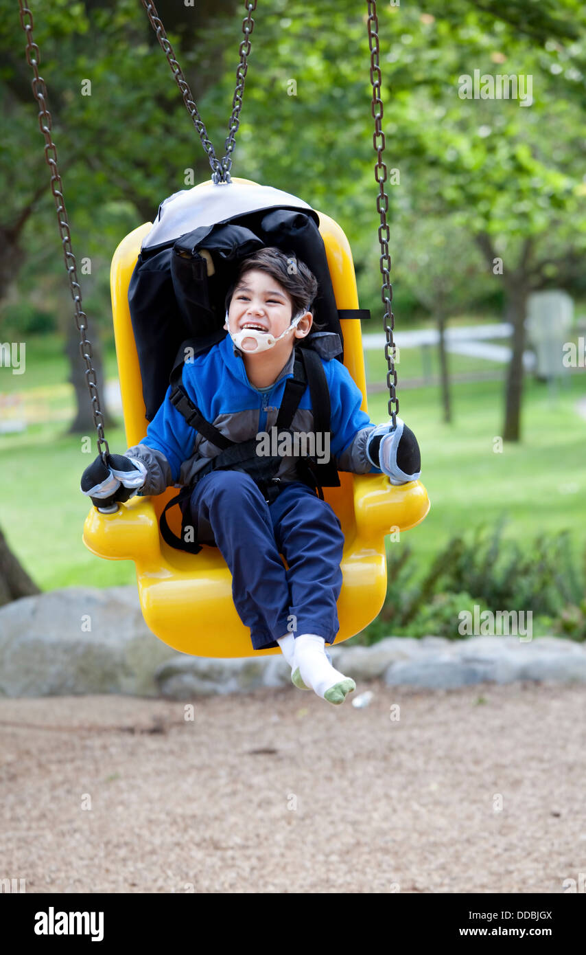 Père fils handicapé poussant sur le handicap swing Banque D'Images