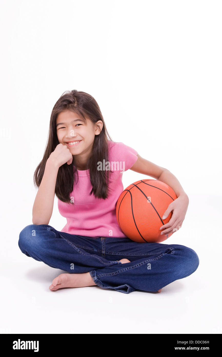 Dix ans Asian girl holding basket-ball, isolated on white Photo Stock -  Alamy