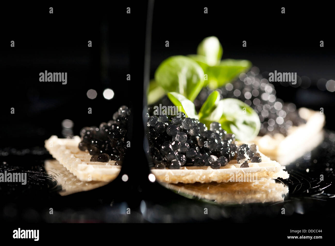 Des sandwichs avec du caviar noir sur fond noir Banque D'Images