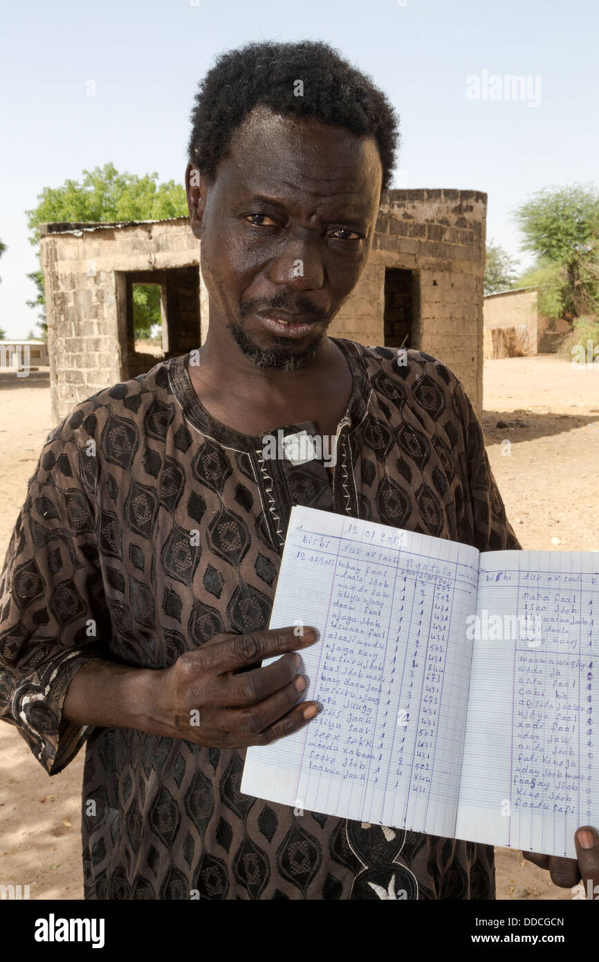 Débarras Steward montre Livre d'inventaire à Bijam, un village Wolof, près de Kaolack, Sénégal. Banque D'Images