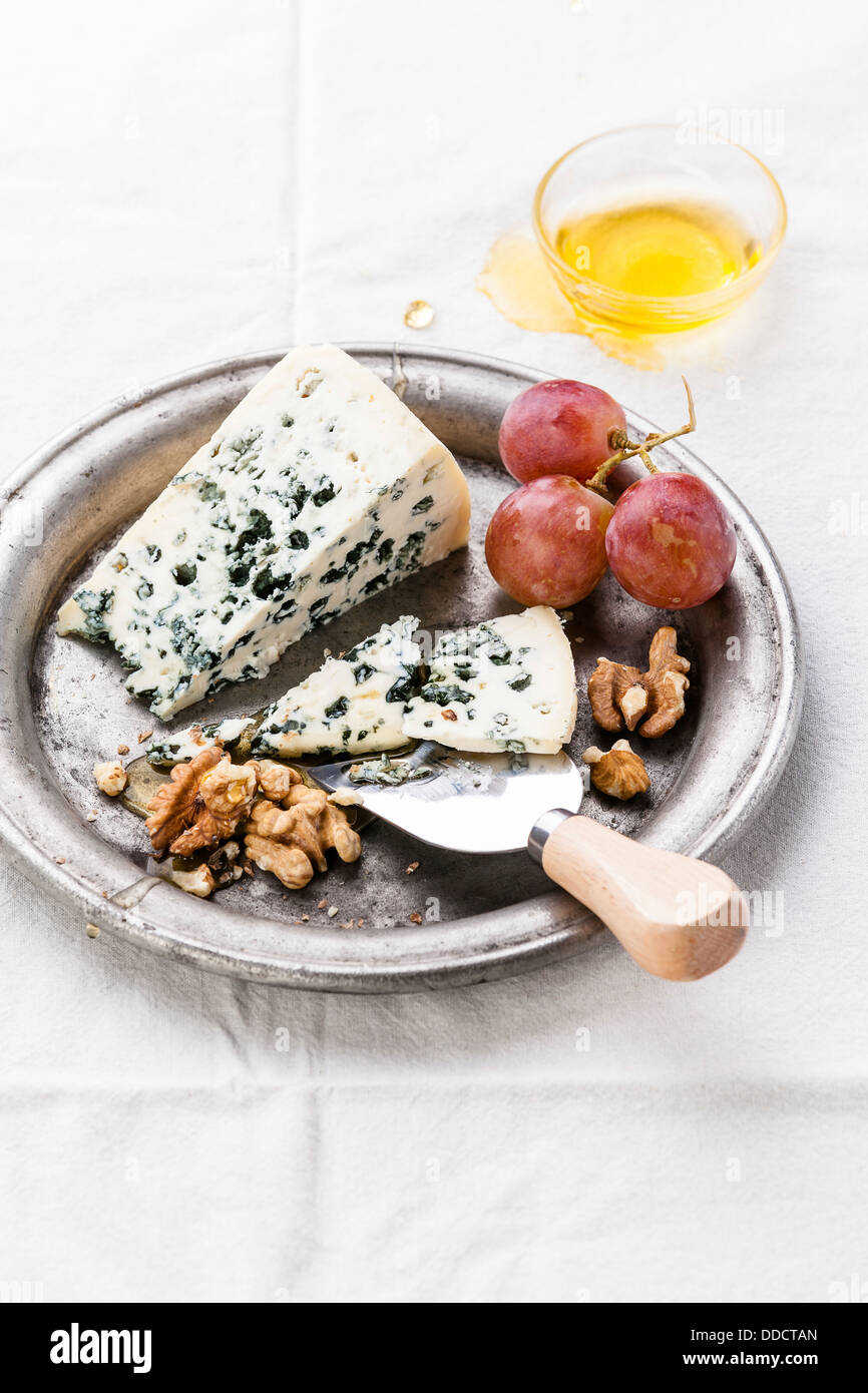 Fromage bleu avec du miel, les noix et les raisins sur la plaque Banque D'Images