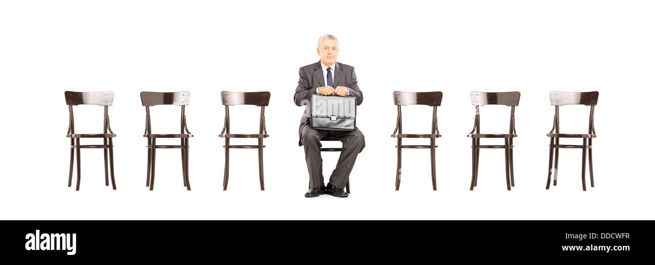 Man in suit holding une serviette en cuir et en attente d'entrevue d'emploi sur une chaise Banque D'Images